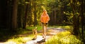 Young woman and dog running together on country in forest. Cheerful female exercising outdoor with her pet. Royalty Free Stock Photo