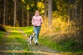 Young woman and dog running together on country in forest. Cheerful female exercising outdoor with her pet Royalty Free Stock Photo