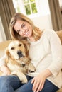 Young woman with dog sitting on sofa