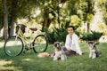 Young woman with dogs and bicycle having picnic in the park Royalty Free Stock Photo