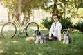 Young woman with dogs and bicycle having picnic in the park Royalty Free Stock Photo