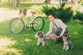 Young woman with dogs and bicycle having picnic in the park Royalty Free Stock Photo