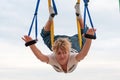 Young woman doing anti-gravity aerial yoga on sky background. Royalty Free Stock Photo