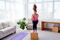 Young woman doing box jump exercise in living room at home, copy space. Jumping squats. Sport, healthy lifestyle concept. Royalty Free Stock Photo