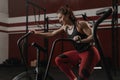 Young woman doing cardio workout using exercise bike at the crossfit gym Royalty Free Stock Photo