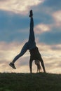 Young woman doing cartwheel on the grass Morning workout beautiful sunrise Royalty Free Stock Photo