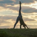 Young woman doing cartwheel on the grass Morning workout beautiful sunrise Royalty Free Stock Photo