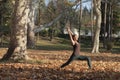 young woman doing high lunge yoga pose in the park Royalty Free Stock Photo