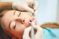 Young woman doing a dental treatment inside professional dentist studio - People bodycare and stomatology concept for healthy