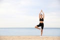 Young woman doing exercise on beach, space for text. Body training Royalty Free Stock Photo
