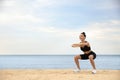 Young woman doing exercise on beach, space for text. Body training Royalty Free Stock Photo