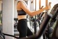 Young woman doing exercise cardio on elliptical trainer at gym