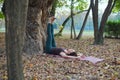 young woman doing exercise outdoors next to the tree Royalty Free Stock Photo