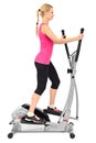 Young woman doing exercises on elliptical trainer Royalty Free Stock Photo