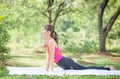Young woman doing exercises in yoga pose in the park, Side view of slim sportswoman doing stretching exercise at summer green Royalty Free Stock Photo