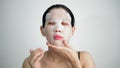 Young woman doing facial mask sheet