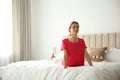 Young woman doing gymnastics on bed at home. Morning fitness Royalty Free Stock Photo