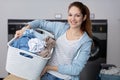 Young woman doing weekly washing in laundromat Royalty Free Stock Photo