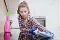 Young woman doing housework, cleaning the kitchen