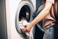 Young woman doing laundry at home. Washing machine and clothes. Generative AI Royalty Free Stock Photo