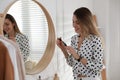 Young woman doing makeup near mirror at home. Morning routine Royalty Free Stock Photo