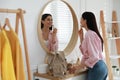 Young woman doing makeup near mirror at home. Morning routine Royalty Free Stock Photo