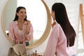 Young woman doing makeup near mirror at home Royalty Free Stock Photo