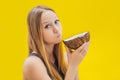 Young woman doing oil pulling over yellow background