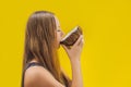 Young woman doing oil pulling over yellow background Royalty Free Stock Photo