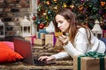 Young woman doing online shopping with credit card and laptop at home. Christmas shopping concept Royalty Free Stock Photo