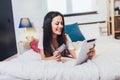 Woman doing online shopping through tablet PC and credit card in bed Royalty Free Stock Photo