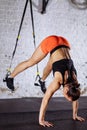 Woman doing push-ups while legs hanging on trx Royalty Free Stock Photo