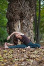 young woman doing revolved seated angle yoga pose