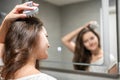 Young woman doing self hair scalp massage with scalp massager or hair brush for hair growth stimulating at home Royalty Free Stock Photo