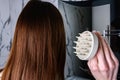 Young woman doing self hair scalp massage with scalp massager for hair growth stimulating at home. Royalty Free Stock Photo