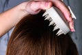 Young woman doing self hair scalp massage with scalp massager for hair growth stimulating at home. Royalty Free Stock Photo