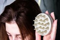 Young woman doing self hair scalp massage with scalp massager for hair growth stimulating at home. Royalty Free Stock Photo