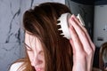 Young woman doing self hair scalp massage with scalp massager for hair growth stimulating at home. Royalty Free Stock Photo