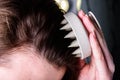 Young woman doing self hair scalp massage with scalp massager for hair growth stimulating at home. Royalty Free Stock Photo