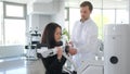 A young woman is doing a spinal examination in a diagnostic machine with a physiotherapist.