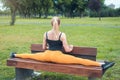 young woman doing split on a bench in the park