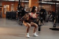 Young woman doing squats with barbell in gym. Sport, fitness, powerlifting and people concept. Royalty Free Stock Photo