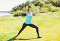 Young woman doing stretching exercises on grass in summer day Royalty Free Stock Photo