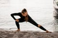 Young woman doing stretching exercises on the sandy river bank Royalty Free Stock Photo