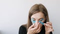 Young woman doing the taping around the eyes to rejuvenate