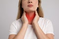 Young woman doing thyroid self examination on light grey background, closeup Royalty Free Stock Photo