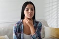 Young woman doing thyroid self examination at home