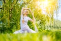 young woman doing yoga asana in park. girl stretching exercise in yoga position. happy and healthy woman sitting in Royalty Free Stock Photo