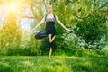 young woman doing yoga asana in park. girl stretching exercise in yoga position. happy and healthy woman sitting in Royalty Free Stock Photo