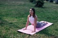 Young woman is doing yoga. Attractive woman in sports clothes lies on exercise mat in Cobra pose, performing